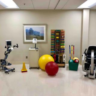 A well-equipped rehabilitation room featuring various fitness and therapy tools.