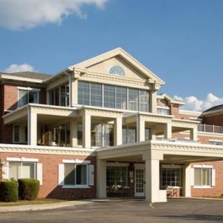 A multi-story residential building with a prominent entrance and large windows.
