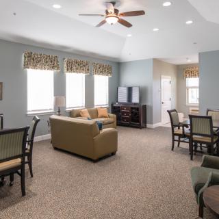 A spacious living room featuring comfortable seating, a dining area, and large windows.