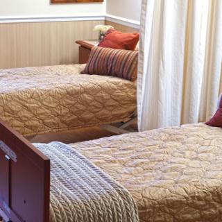 A cozy bedroom featuring two twin beds with decorative bedding and pillows.