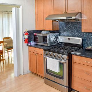 A modern kitchen with wooden cabinets featuring a stove, oven, and microwave.
