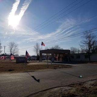 A clear day with flags waving in the breeze, set against a backdrop of scattered clouds.