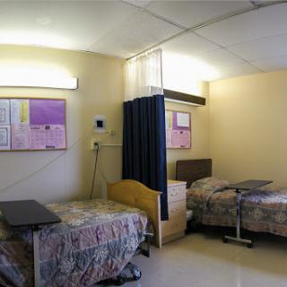 A view of a hospital room with two beds separated by a curtain, highlighting the typical environment for patient care.