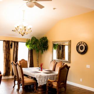A warm and elegant dining room with a chandelier, wooden furniture, and decorative elements.