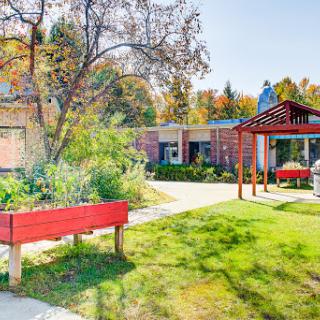 A vibrant outdoor space showcasing a garden and a cozy seating area, perfect for enjoying the fall scenery.