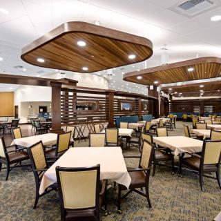 An elegant restaurant dining area with well-arranged tables and unique ceiling designs.