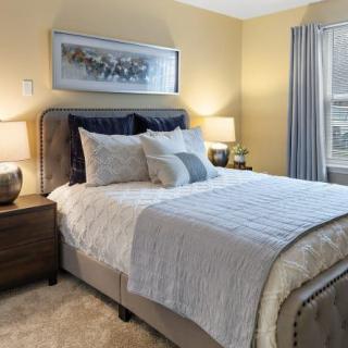 A cozy, well-decorated bedroom featuring a comfortable bed with neutral tones and stylish decor.