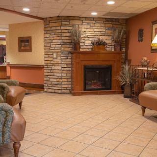 A cozy and welcoming lobby featuring a stone fireplace and comfortable seating.