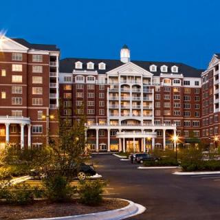 A well-lit hotel exterior with classic architecture during nighttime.