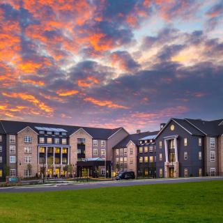 A hotel building with a dramatic sunset sky in the background.