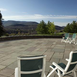 A serene patio with chairs overlooking a scenic mountain landscape.