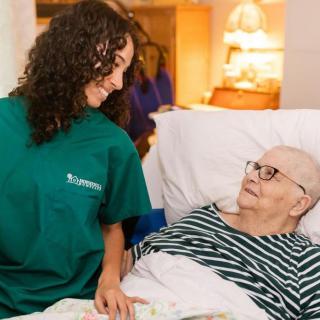 A nurse providing care to an elderly patient in a hospital setting.