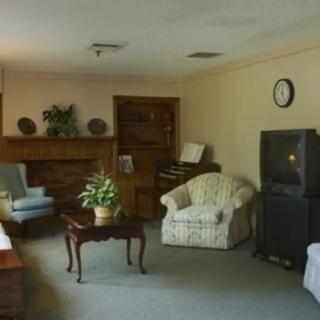 A cozy living room with armchairs, a television, and a coffee table.