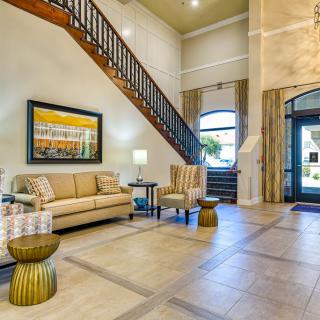 A bright and modern lobby featuring comfortable seating and a stylish staircase.