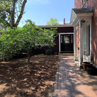 A serene view of a home garden with a pathway leading to the entrance.