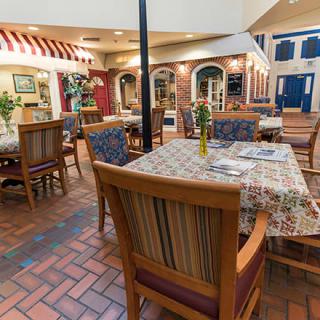 A cozy restaurant interior featuring multiple tables and chairs, with a charming decor.