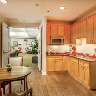 A cozy, modern kitchen and dining area with wooden cabinets and warm lighting.