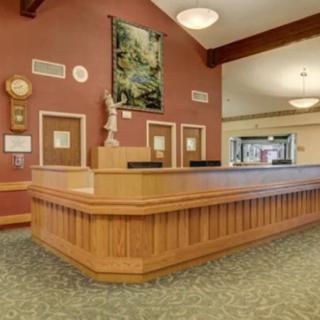 A hotel lobby featuring a wooden reception desk and warm decor.