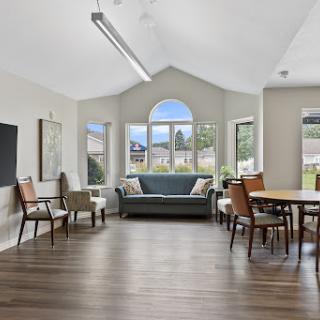 A bright and airy living space featuring comfortable seating, large windows, and a modern aesthetic.