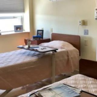 A clean and organized hospital room with two beds.