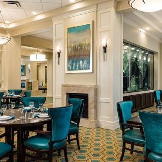 A well-decorated restaurant dining area with teal chairs and neatly set tables.