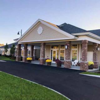A welcoming exterior of a well-maintained building with lush landscaping and colorful flowers.