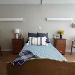A well-furnished and cozy bedroom with a neatly made bed, stylish pillows, and warm lighting.