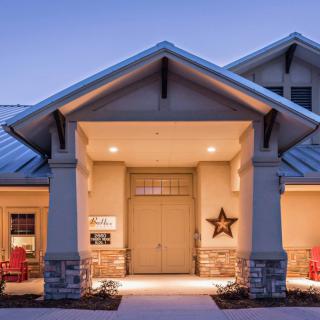 A well-lit residential house with a welcoming front porch during the evening.