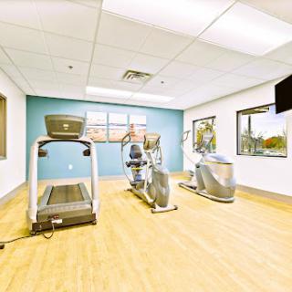 A bright and spacious gym featuring various cardio machines for all your fitness needs.