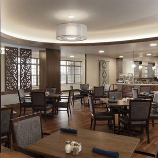 A modern dining area with neatly arranged tables and chairs, complemented by elegant lighting and decor.