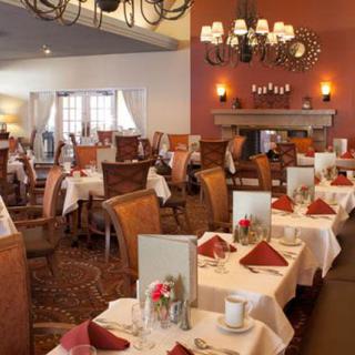 An elegant restaurant dining room with neatly set tables and a warm ambiance.