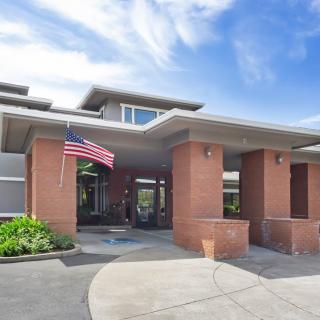 Front entrance of a modern building with an American flag.
