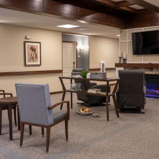 A modern living room space with comfortable seating and a large TV.