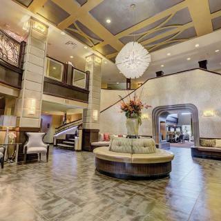 A luxurious hotel lobby with elegant seating and a grand chandelier.