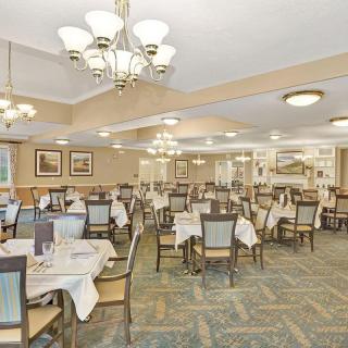 An elegant dining room with neatly arranged tables and chandeliers.