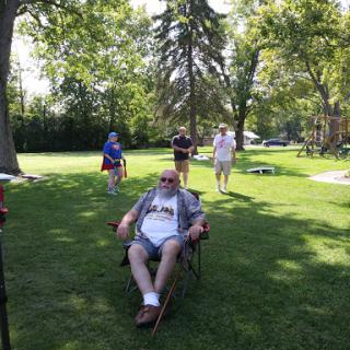 A sunny day picnic gathering with people enjoying the outdoors.
