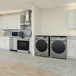 A modern kitchen featuring stainless steel appliances, including a washer and dryer.