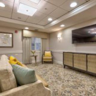 A cozy living room with a sofa and a large television.