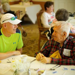 Two people enjoying a conversation at a dining table.