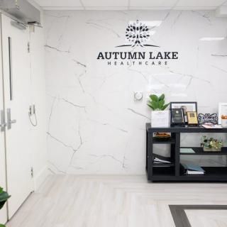 A modern office reception area with Autumn Lake Healthcare signage on a marble wall.