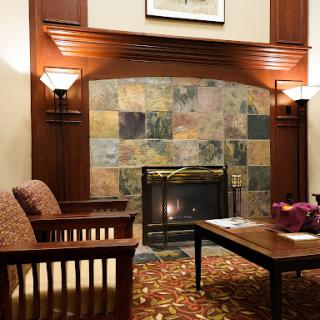 A cozy lobby area featuring comfortable seating and a decorative fireplace.