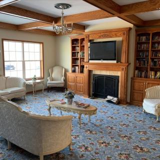 A cozy living room with traditional furniture, featuring a fireplace and built-in bookshelves.