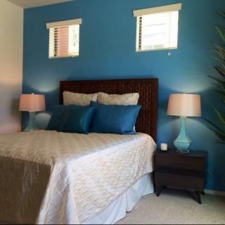 A cozy bedroom with a blue accent wall and stylish decor.