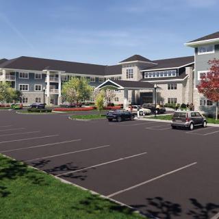 A modern residential building with a spacious parking lot and surrounding landscaping.