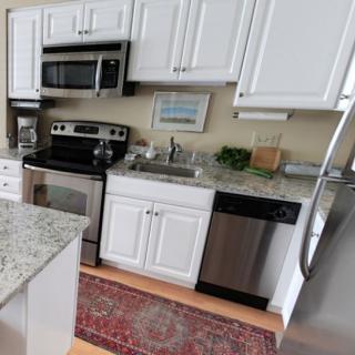 A modern kitchen with white cabinets and stainless steel appliances.