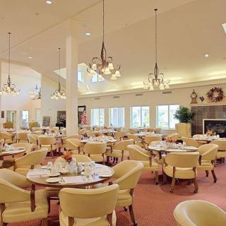A spacious and elegantly designed dining area with neatly arranged tables and comfortable seating.