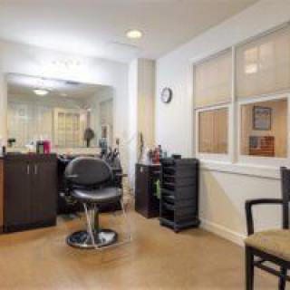 A modern hair salon interior with styling chair and mirror.