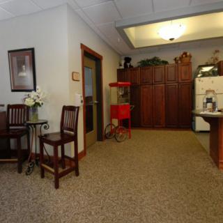 A cozy waiting room with chairs, a table, and decorative elements.