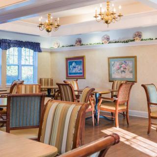 A cozy dining room with elegant chandeliers and comfortable seating.