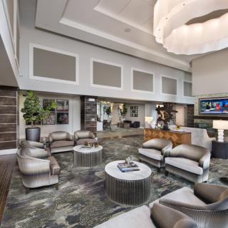 A luxurious modern living room with high ceilings and elegant furniture.